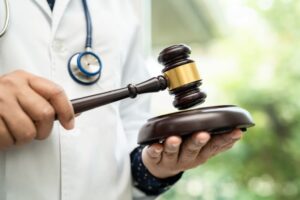 Doctor holding a gavel symbolizing Good Samaritan legal protection for bystanders