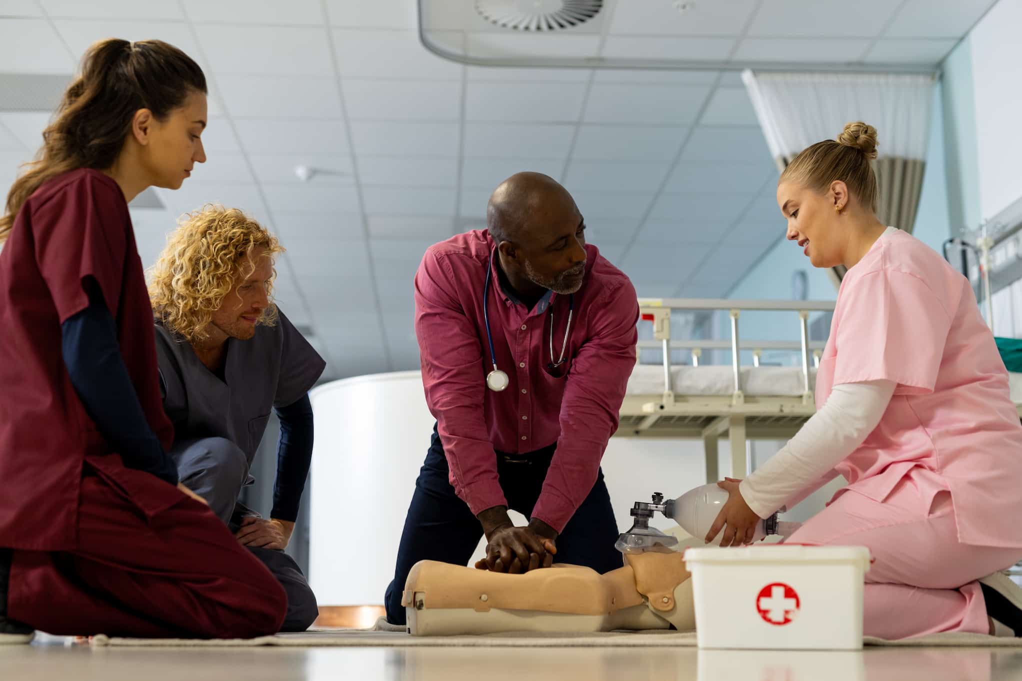 Medical team practicing CPR on a training manikin in a hospital setting
