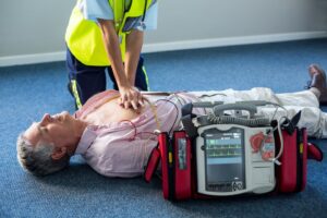 Paramedic performing CPR with defibrillator on cardiac arrest patient